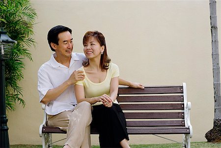 Mature couple sitting on bench, man with arms around woman Stock Photo - Premium Royalty-Free, Code: 656-01769238