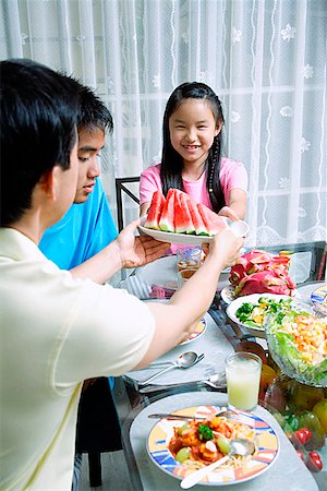 simsearch:656-01769317,k - Father passing food to daughter at dining table Stock Photo - Premium Royalty-Free, Code: 656-01769324
