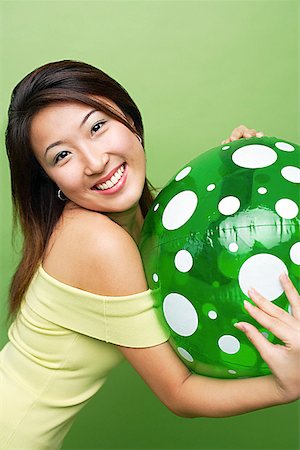 simsearch:656-01773586,k - Woman hugging inflatable ball, smiling at camera Stock Photo - Premium Royalty-Free, Code: 656-01769418