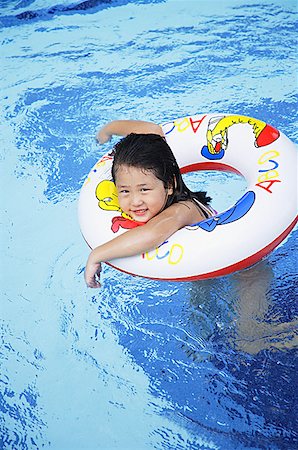 Girl in swimming pool using inflatable ring Stock Photo - Premium Royalty-Free, Code: 656-01769475