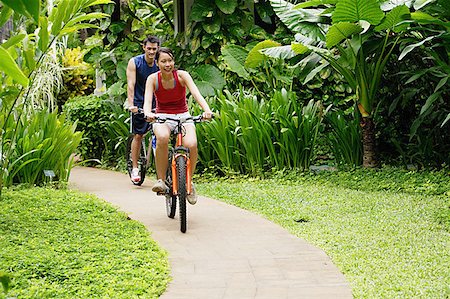 simsearch:656-01773586,k - Couple cycling leisurely through a park Stock Photo - Premium Royalty-Free, Code: 656-01769552