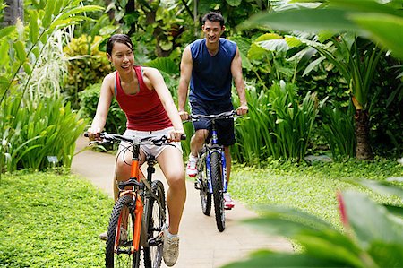 simsearch:656-01773586,k - Couple cycling through a park, smiling Stock Photo - Premium Royalty-Free, Code: 656-01769553