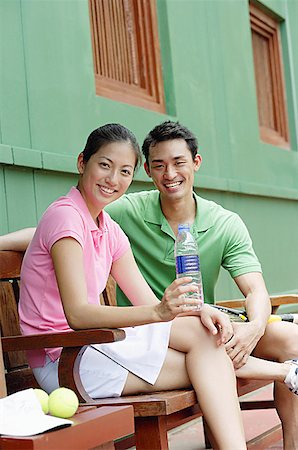 friends tennis - Man and woman sitting on bench, smiling at camera, woman with water bottle Stock Photo - Premium Royalty-Free, Code: 656-01769565