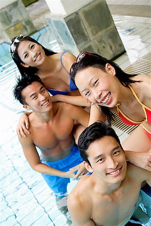 swimming pool leaning on edge - Young adults in swimming pool, smiling at camera Stock Photo - Premium Royalty-Free, Code: 656-01769664