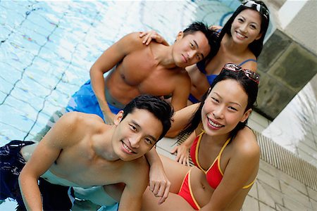 swimming pool leaning on edge - Young adult couples in swimming pool, smiling at camera, portrait Stock Photo - Premium Royalty-Free, Code: 656-01769665