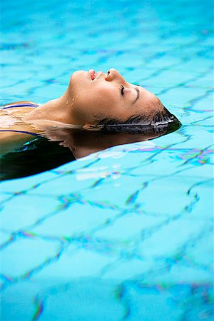 Woman floating in swimming pool Stock Photo - Premium Royalty-Free, Code: 656-01769688