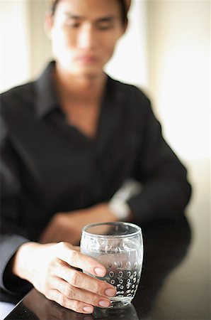 simsearch:656-01773560,k - Man sitting at counter, holding drink Stock Photo - Premium Royalty-Free, Code: 656-01769947