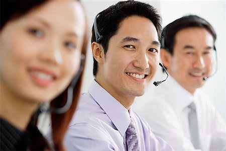simsearch:628-02954142,k - Executives wearing headsets, smiling at camera Fotografie stock - Premium Royalty-Free, Codice: 656-01770028