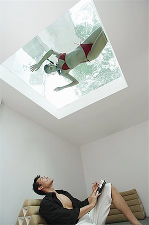 simsearch:656-01770411,k - Man looking at woman in swimming pool through the skylight Foto de stock - Royalty Free Premium, Número: 656-01770443