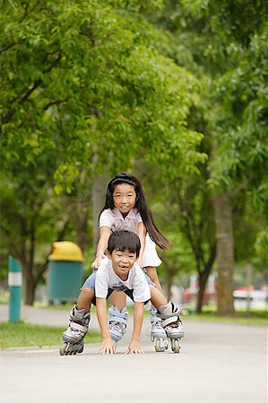 rollerblade girl - Children rollerblading, boy falling down Stock Photo - Premium Royalty-Free, Code: 656-01770521