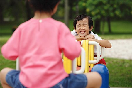 simsearch:656-01773586,k - Two girls on a seesaw, one leaning on arms, smiling, eyes closed Stock Photo - Premium Royalty-Free, Code: 656-01770579