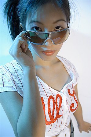 simsearch:656-01770941,k - Young woman adjusting sunglasses, looking at camera Foto de stock - Sin royalties Premium, Código: 656-01770618