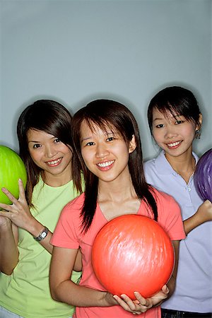 simsearch:656-01770741,k - Three young women with bowling balls, smiling Foto de stock - Royalty Free Premium, Número: 656-01770659