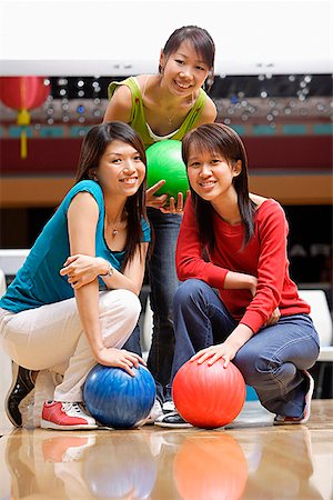 simsearch:656-01770739,k - Three women in bowling alley, holding bowling balls Fotografie stock - Premium Royalty-Free, Codice: 656-01770668