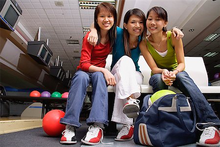 simsearch:656-01770741,k - Women sitting side by side in bowling alley, smiling at camera Foto de stock - Royalty Free Premium, Número: 656-01770681