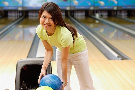 Femme en sélectionnant la boule de bowling, souriant à la caméra Photographie de stock - Premium Libres de Droits, Code: 656-01770698