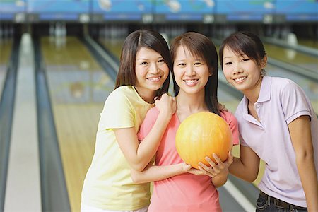 simsearch:656-01770739,k - Three women at bowling alley, smiling at camera Fotografie stock - Premium Royalty-Free, Codice: 656-01770724