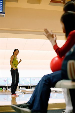 simsearch:656-01770741,k - Woman at bowling alley, turning to look at friends behind her Foto de stock - Royalty Free Premium, Número: 656-01770738