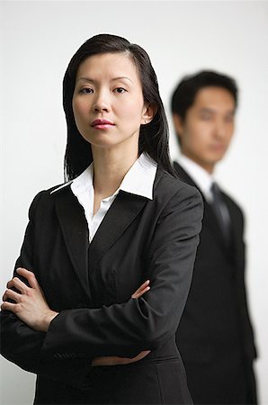 executive mentor - Businesswoman with arms crossed, man in the  background Stock Photo - Premium Royalty-Free, Code: 656-01770824