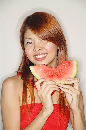Woman holding a slice of watermelon, smiling Stock Photo - Premium Royalty-Free, Code: 656-01771038