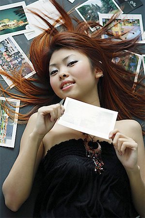 postcard - Woman lying on floor, holding postcard Stock Photo - Premium Royalty-Free, Code: 656-01771050