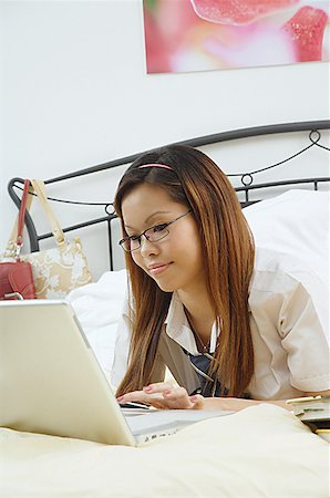 simsearch:656-01766118,k - Girl lying on bed, using laptop Foto de stock - Royalty Free Premium, Número: 656-01771194