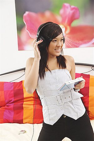 Girl in bedroom, listening to headphones Stock Photo - Premium Royalty-Free, Code: 656-01771208
