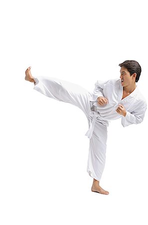 simsearch:656-03241028,k - Young man practicing martial arts uniform, kicking with one leg Foto de stock - Sin royalties Premium, Código: 656-01771277