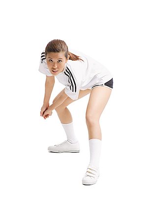 Young woman bending, hands clasped, waiting to hit ball Stock Photo - Premium Royalty-Free, Code: 656-01771283