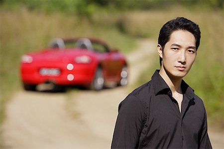 rich and arrogant man - Man looking at camera, red sports car in the background, portrait Stock Photo - Premium Royalty-Free, Code: 656-01771411