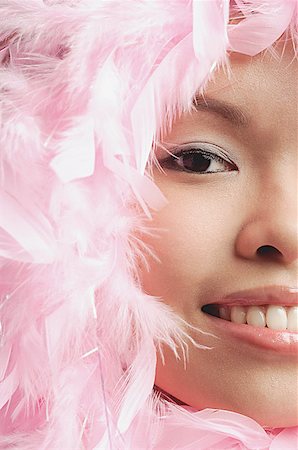 Woman with pink feathers around her face, cropped image Stock Photo - Premium Royalty-Free, Code: 656-01771535