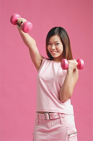 simsearch:656-01769580,k - Woman dressed in pink, using dumbbells Foto de stock - Sin royalties Premium, Código: 656-01771538