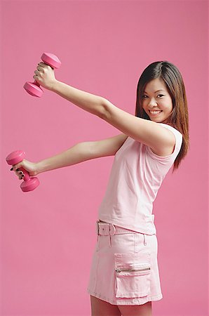 simsearch:656-01769580,k - Woman dressed in pink, lifting dumbbell Foto de stock - Sin royalties Premium, Código: 656-01771540