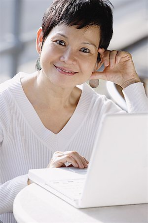 simsearch:656-03519571,k - Mature woman with laptop, smiling at camera Foto de stock - Sin royalties Premium, Código: 656-01771566