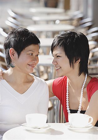 Mother and adult daughter in cafe smiling at each other Stock Photo - Premium Royalty-Free, Code: 656-01771580