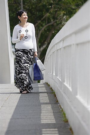 simsearch:656-01771655,k - Mature woman carrying shopping bags, walking along bridge Foto de stock - Sin royalties Premium, Código: 656-01771626