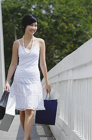 simsearch:656-01771655,k - Woman dressed in white carrying shopping bags Foto de stock - Sin royalties Premium, Código: 656-01771629