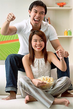 Couple in living room, man sitting on sofa, woman on floor Stock Photo - Premium Royalty-Free, Code: 656-01771685