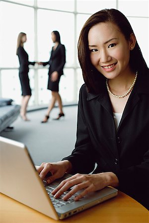 simsearch:693-03303488,k - Portrait of businesswoman using laptop, smiling at camera Foto de stock - Sin royalties Premium, Código: 656-01771793
