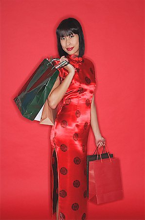 simsearch:656-03076309,k - Woman in red cheongsam, carrying shopping bags Fotografie stock - Premium Royalty-Free, Codice: 656-01771878