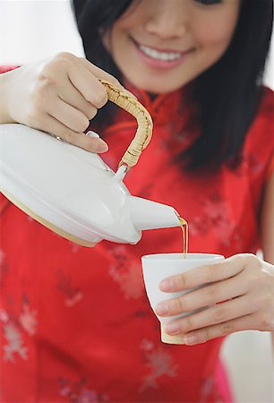 simsearch:656-01771940,k - Woman pouring tea from teapot Fotografie stock - Premium Royalty-Free, Codice: 656-01771944