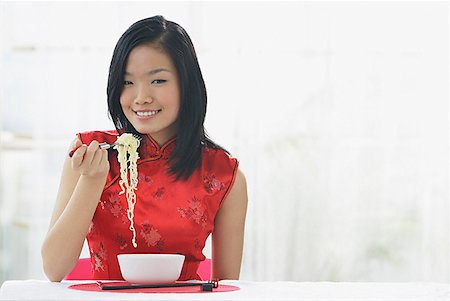 Woman eating bowl of noodles Stock Photo - Premium Royalty-Free, Code: 656-01771941