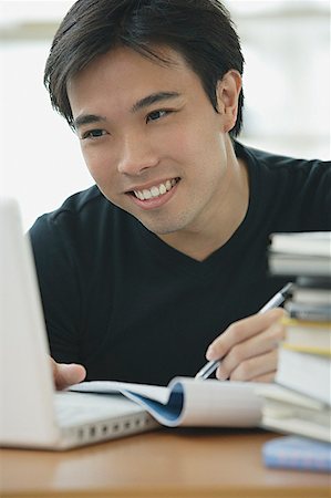 student computer writing - Young adult looking at laptop, writing in notebook Stock Photo - Premium Royalty-Free, Code: 656-01771954