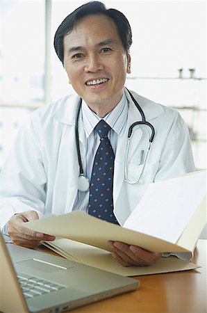 simsearch:656-01772656,k - Doctor smiling at camera, holding folder Stock Photo - Premium Royalty-Free, Code: 656-01771967