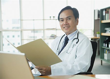 simsearch:656-01772656,k - Doctor sitting in office, smiling at camera Stock Photo - Premium Royalty-Free, Code: 656-01771969