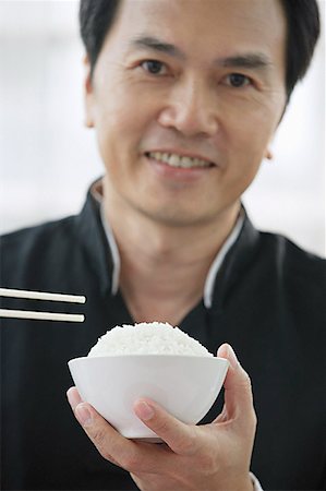 simsearch:656-01771940,k - Man with bowl of rice and chopsticks Fotografie stock - Premium Royalty-Free, Codice: 656-01771976