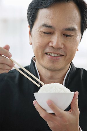 simsearch:656-01771940,k - Man eating rice Foto de stock - Sin royalties Premium, Código: 656-01771977