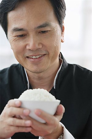simsearch:656-01771940,k - Man looking at bowl of rice in his hands Fotografie stock - Premium Royalty-Free, Codice: 656-01771979