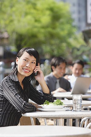 simsearch:656-01773928,k - Businesswoman using mobile phone at outdoor cafe, people in the background Foto de stock - Royalty Free Premium, Número: 656-01772138