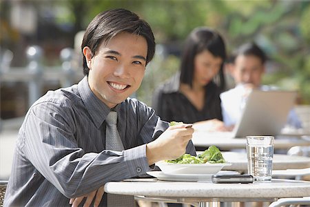 simsearch:628-02954142,k - Businessman having lunch at outdoor cafe, smiling at camera Fotografie stock - Premium Royalty-Free, Codice: 656-01772141